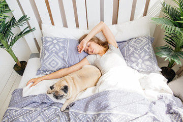 Young woman with her dog in a bed. Breakfast in bed