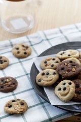 groups of Delicious Chocolate Chip Cookies on black plate, Tasty Homemade cookies on wooden table, dessert with copy space