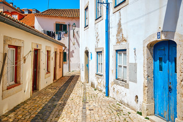 Fototapeta na wymiar Ancient street of Lisbon old town in Alfama district. Vintage