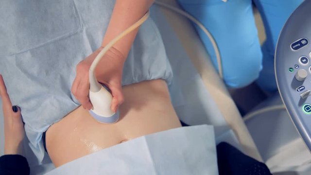 Top view of a female stomach during ultrasonic session. Medical ultrasound scan.