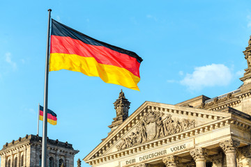 German flags waving at the famous Reichstag building, seat of the German Parliament, politics and tourism concept