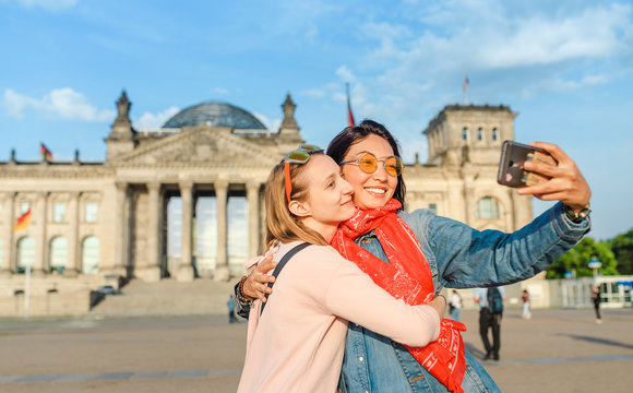 Two happy woman making selfie on background of Reichstag Bundestag building in Berlin. Travel and love concept in Europe