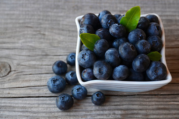 Freshly picked blueberries in a bowl on old wooden background.Fresh organic blueberry.
Bilberries.Selective focus.