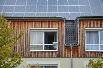 haus mit Solardach und offenen fenster mit Kissen zum lüften