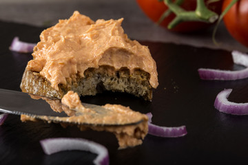 Bitten open sandwich with fish roe and purple onion