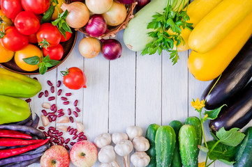 Frame of fresh vegetables and fruits on a white wooden table