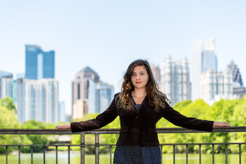 Young woman realtor face standing in Piedmont Park in Atlanta, Georgia scenic water, and cityscape...
