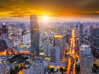 Fototapeta premium Aerial view of Bangkok skyline and skyscraper on Silom road center of business in capital. Modern city and BTS skytrain with Chao Phraya river at Bangkok Thailand on sunrise