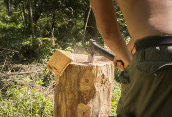 rąbanie siekierą drwa na opał w lesie