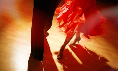 Man and woman dancing Salsa on dark background