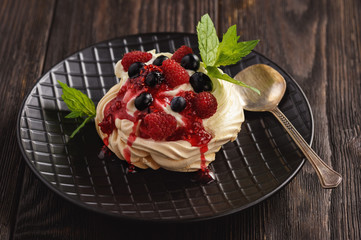 Homemade Pavlova dessert with raspberries and blueberries.