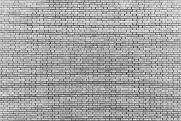 Old realistic brick wall made of gray brick in different shads. Burnt smooth brickwork in grayscale. Monochrome background.