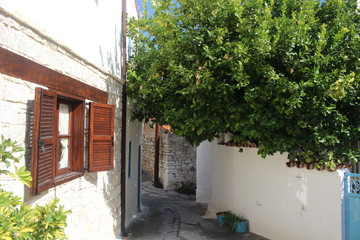 Fototapeta na wymiar Opened window to a narrow street of a small village in a sunny day.