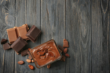 Glass bowl with molten chocolate on wooden table