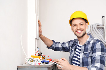 Electrician repairing distribution board indoors