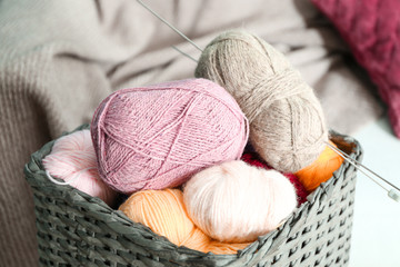 Fototapeta na wymiar Colorful knitting yarn with needles in wicker basket indoors