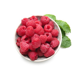 Plate with fresh ripe raspberries on white background