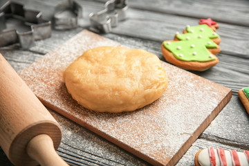 Raw dough for Christmas cookies on wooden board