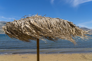 straw parasol, windy day on the beach