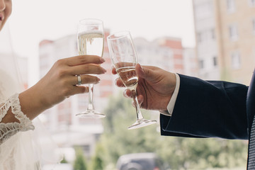 The bride and groom clink glasses with champagne
