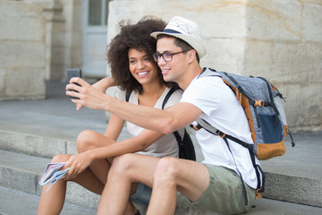 happy couple of tourists taking selfie in old city