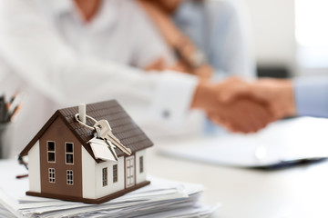 House model with key on table in office of real estate