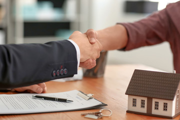 Man shaking hands with real estate in office