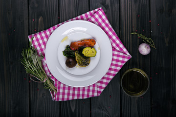 antipasti von oben auf dunklem untergrund mit rot karriertem handtuch und kräutern