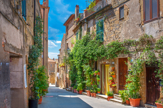 Fototapeta Beautiful flower street in a medieval village in Tuscany. Pitigliano. Italy