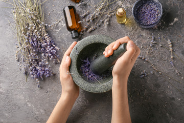 Woman grinding lavender flowers in mortar, top view - obrazy, fototapety, plakaty