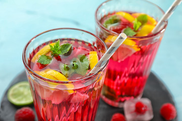 Glasses of fresh raspberry mojito on table, closeup