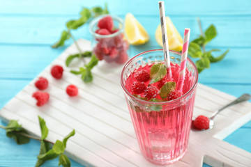Glass of fresh raspberry mojito on board