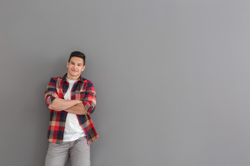 Portrait of handsome young man in casual clothes on grey background