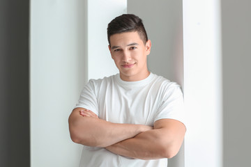 Emotional young man in casual clothes near window