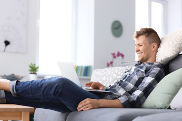 Handsome young man working on laptop at home