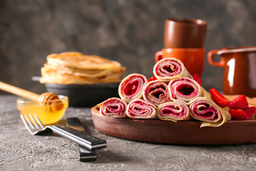 Delicious thin pancakes with berries on grunge table