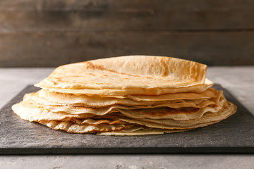 Delicious thin pancakes on slate plate