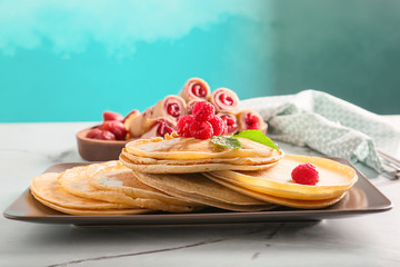 Delicious thin pancakes with berries on plate