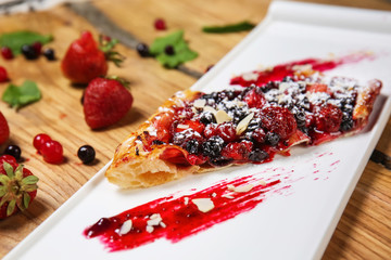 Delicious berry cake with jam on plate, closeup