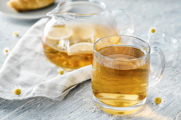 Cup of delicious camomile tea on wooden table, closeup
