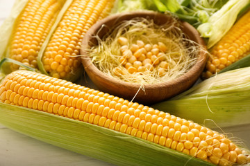Bowl with corn kernels and cobs on table, closeup