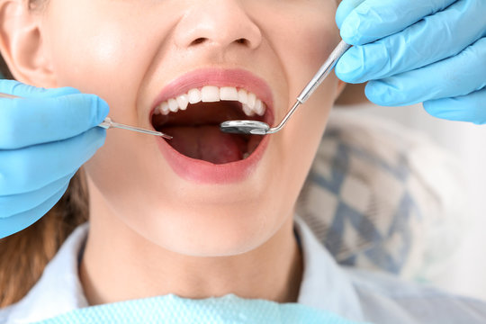 Dentist examining patient's teeth in clinic, closeup