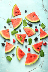Delicious sliced watermelon and berries on light background