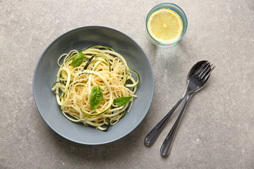 Plate of spaghetti with zucchini on table