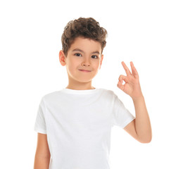 Cute little boy showing OK gesture on white background