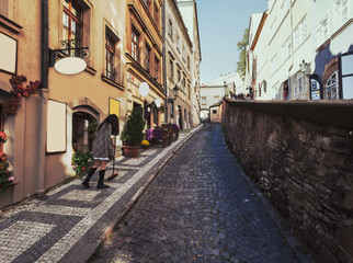 Fototapeta premium Beautiful cobblestoned narrow street with vintage architecture in Prague, Czech Republic
