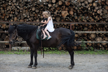 Girls ride on horse on summer day