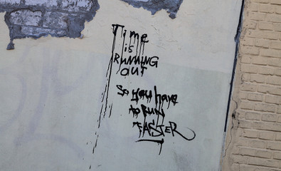 Time is running out graffito on a grey wall