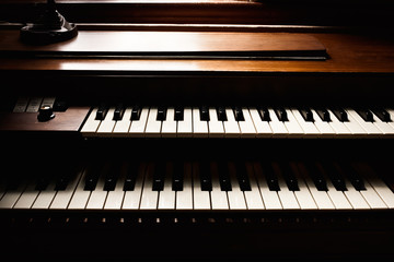 Double keyboard piano detail in natural window light. © Kevin Brine