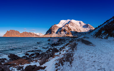 Fototapeta na wymiar Scenic view of beautiful winter sea scandinavian landscape with blue sky, mountains and snow at Lofoten Islands in Northern Norway